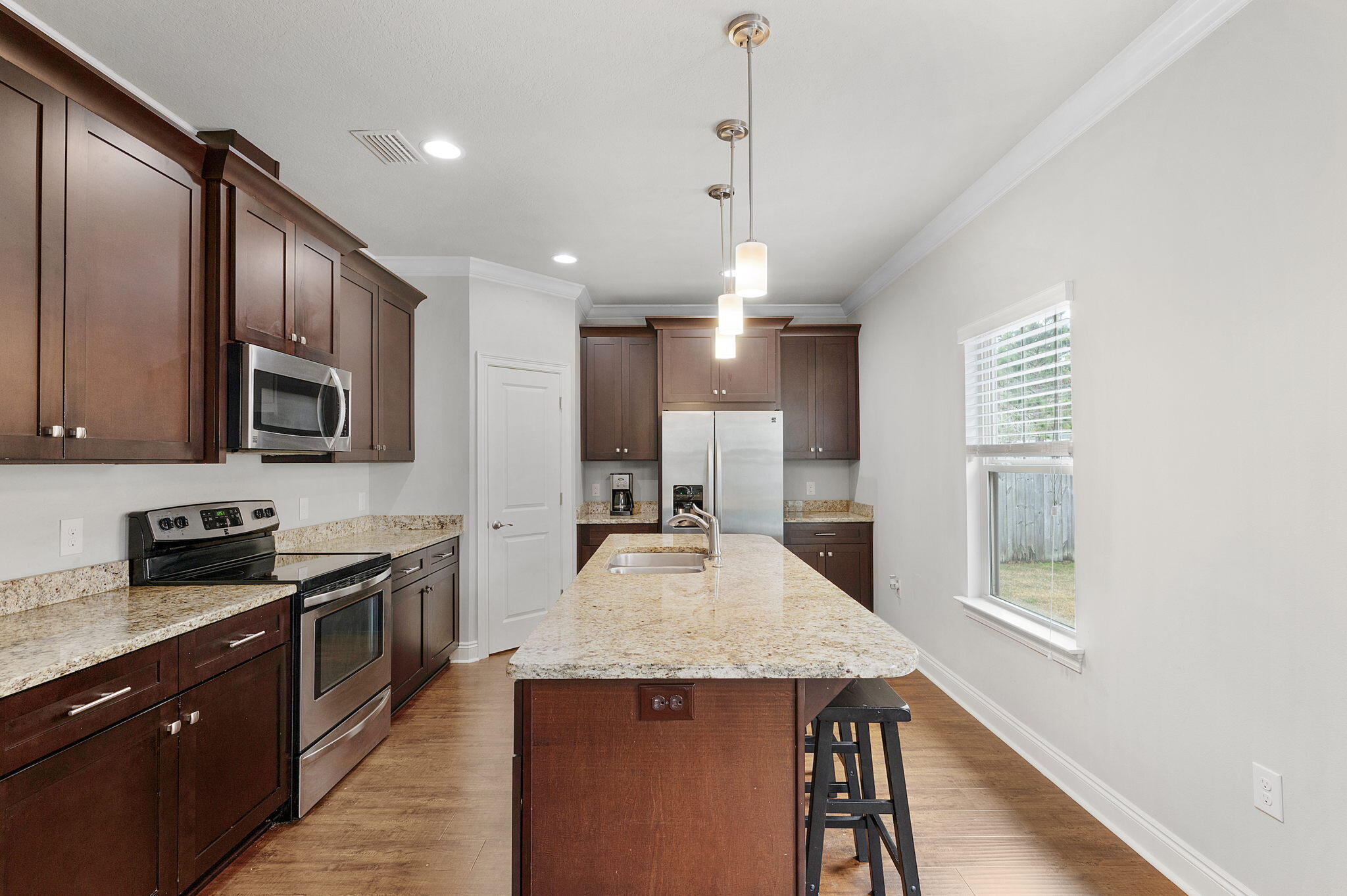 9018 Timber Lane Navarre, FL 32566 - Photo 8 of 39 a kitchen with stainless steel appliances granite countertop a sink refrigerator and microwave