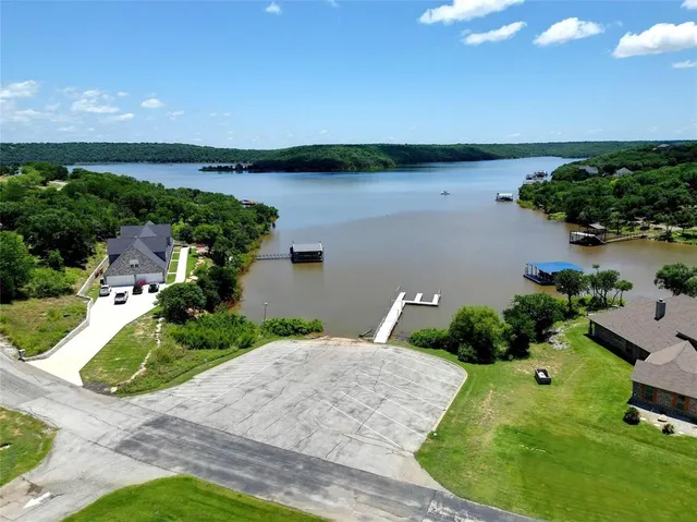 an aerial view of a house with a yard and lake view