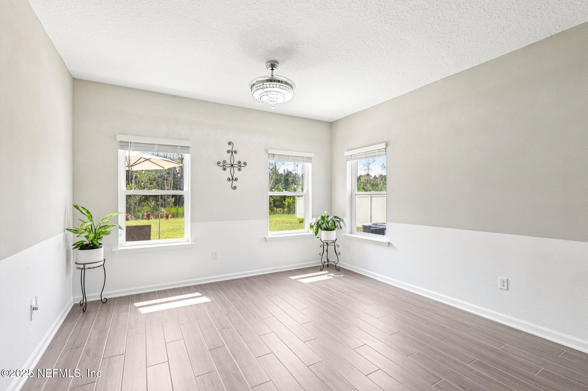 456 Stargaze Lane St. Augustine, FL 32095 - Photo 11 of 40 a view of an empty room with wooden floor and a window