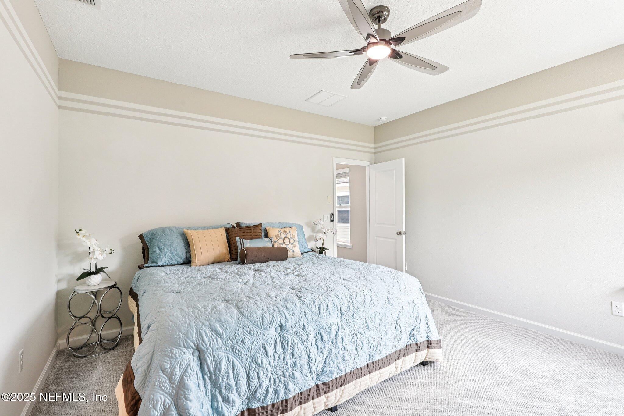 456 Stargaze Lane St. Augustine, FL 32095 - Photo 18 of 40 a bedroom with a bed and a ceiling fan