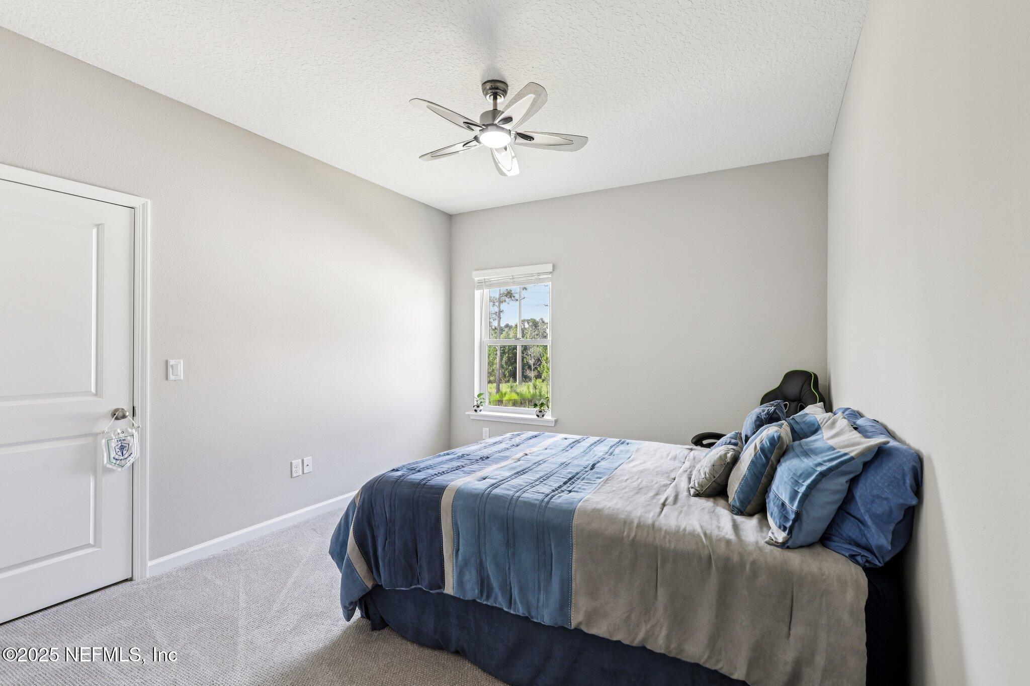 456 Stargaze Lane St. Augustine, FL 32095 - Photo 21 of 40 a bedroom with a bed and a chandelier