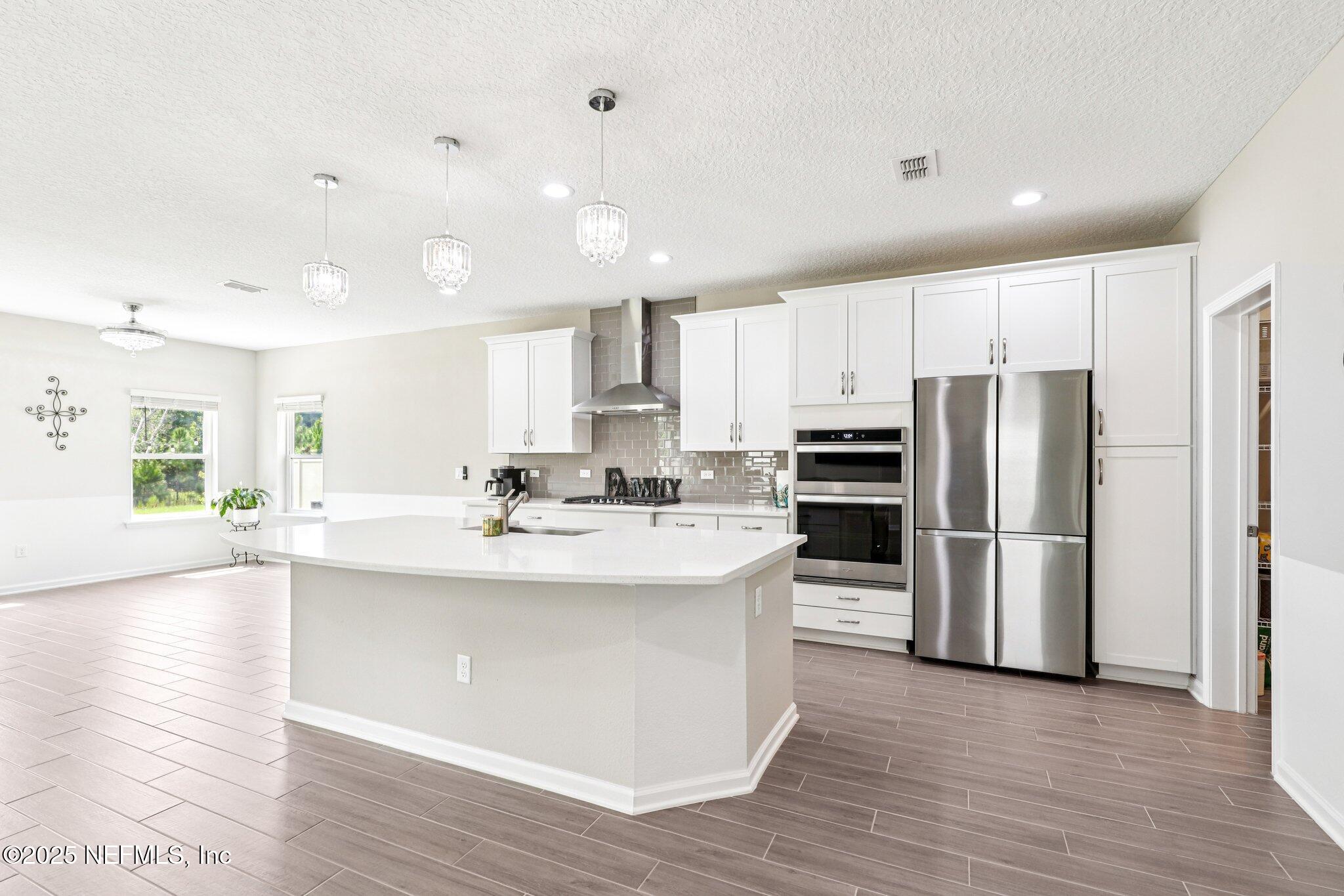 456 Stargaze Lane St. Augustine, FL 32095 - Photo 6 of 40 a kitchen with stainless steel appliances a refrigerator sink and microwave