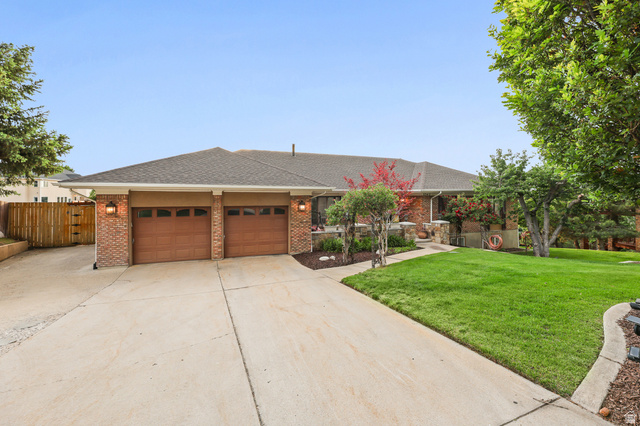 2342 Charros Road Sandy, UT 84092 - Photo 84 of 94 Ranch-style residence featuring a brick facade, two-car garage with wood-finish doors, and a concrete driveway