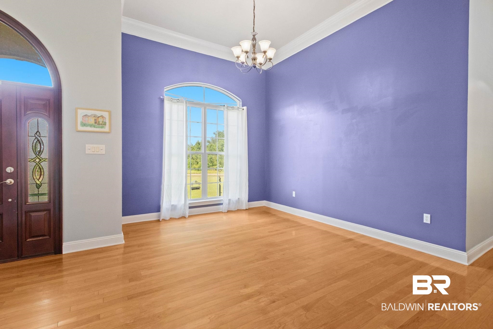 79 Whitetail Run Chatom, AL 36518 - Photo 22 of 82 Spacious interior featuring wood-finish flooring, a decorative arched window with transom, a multi-paneled front door with decorative glass inserts, crown molding, and a chandelier