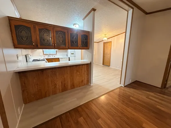 a kitchen with stainless steel appliances granite countertop a sink and cabinets with wooden floor
