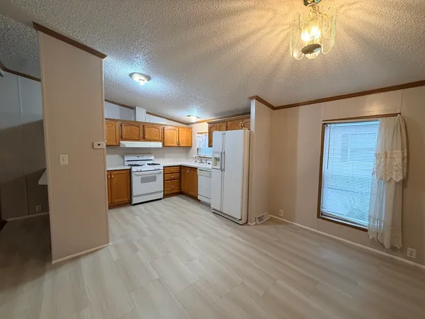 a kitchen with stainless steel appliances granite countertop a refrigerator a stove a sink and dishwasher