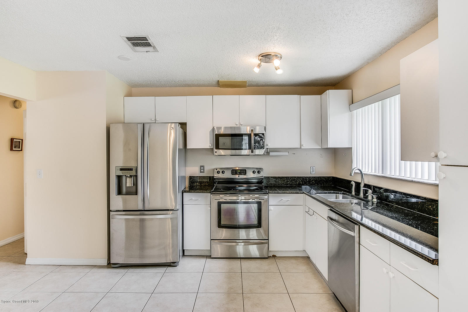 639 Furth Road Northwest Palm Bay, FL 32907 - Photo 11 of 22 a kitchen with a refrigerator sink and cabinets