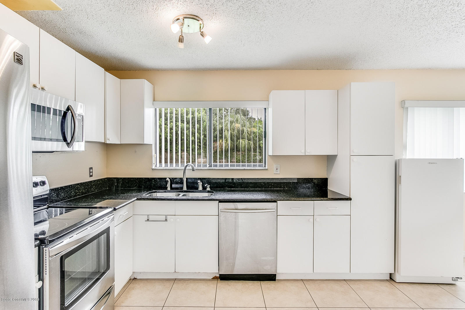 639 Furth Road Northwest Palm Bay, FL 32907 - Photo 12 of 22 a kitchen with granite countertop a sink a stove and cabinets
