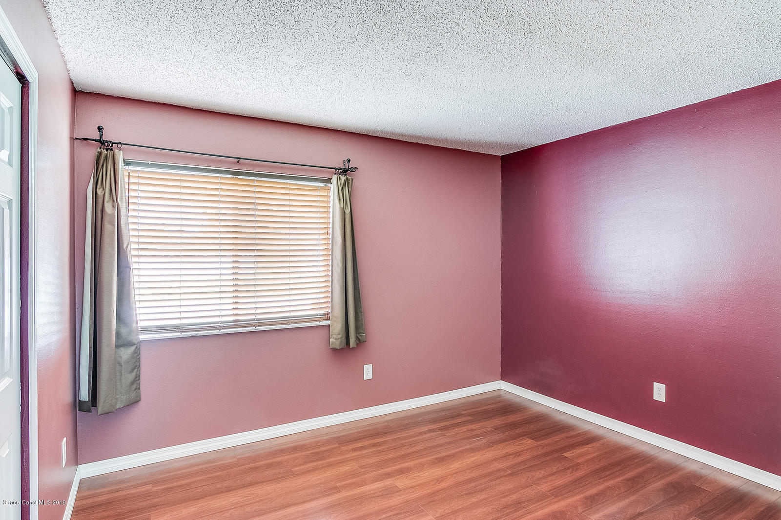 639 Furth Road Northwest Palm Bay, FL 32907 - Photo 17 of 22 a view of an empty room with wooden floor and a window
