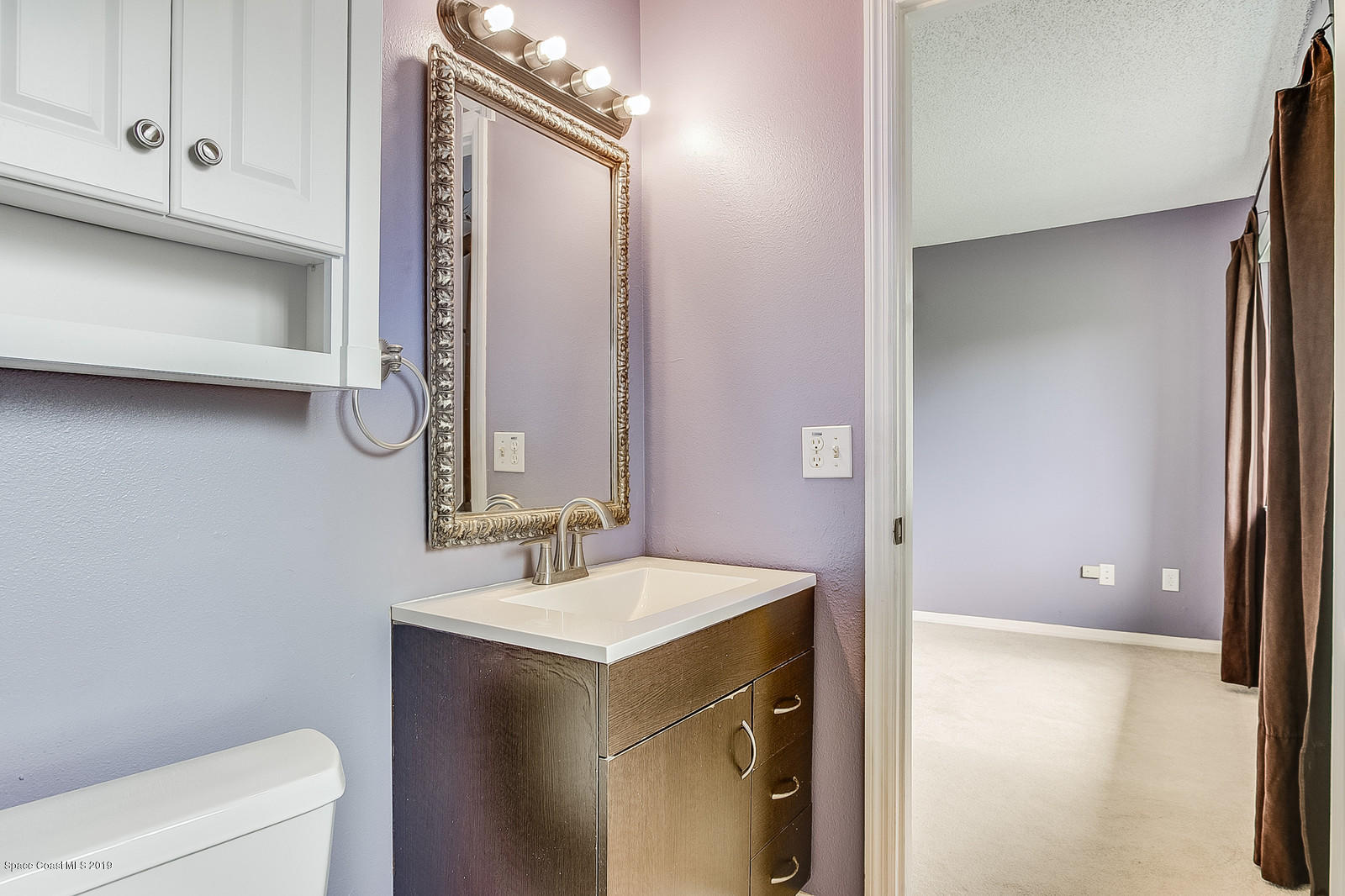 639 Furth Road Northwest Palm Bay, FL 32907 - Photo 21 of 22 a bathroom with a sink a toilet and a mirror