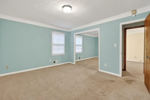 an empty room with windows and closet