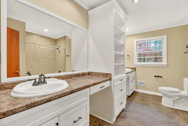 a bathroom with a granite countertop sink double vanity and a mirror