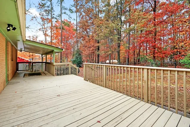 a balcony with wooden floor and trees