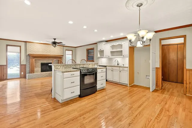 a kitchen with stainless steel appliances granite countertop a sink cabinets and wooden floor