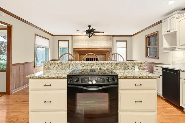 a kitchen with granite countertop a stove sink and refrigerator
