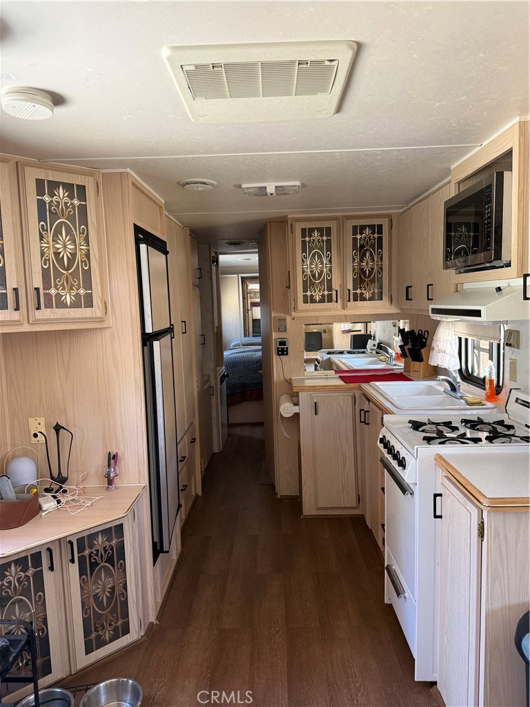 96484 Kennedy Meadow Road Inyokern, CA 93527 - Photo 42 of 42 a kitchen with stainless steel appliances granite countertop a stove top oven a sink dishwasher and a refrigerator with wooden floor