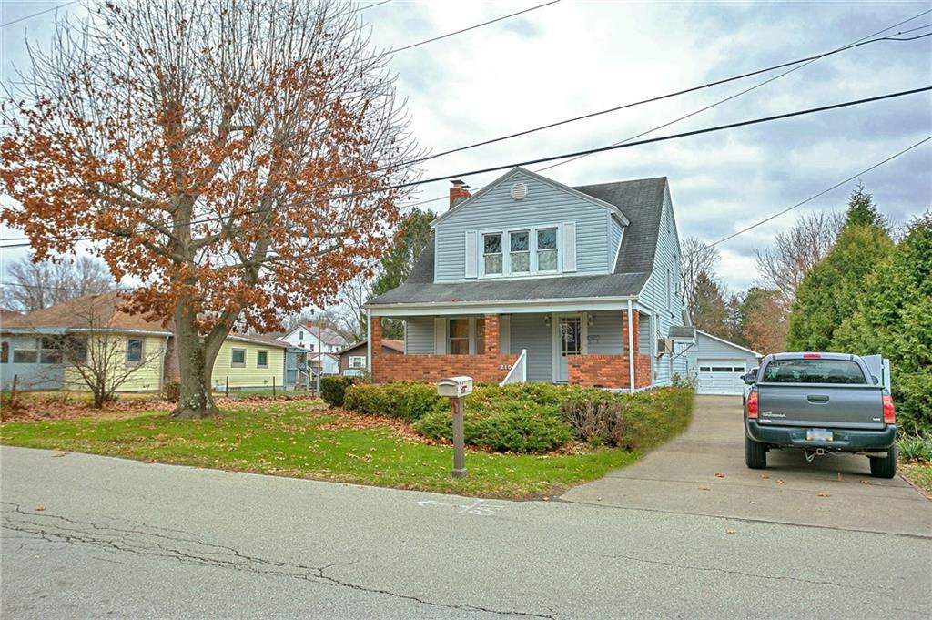 a front view of a house with a garden and parking