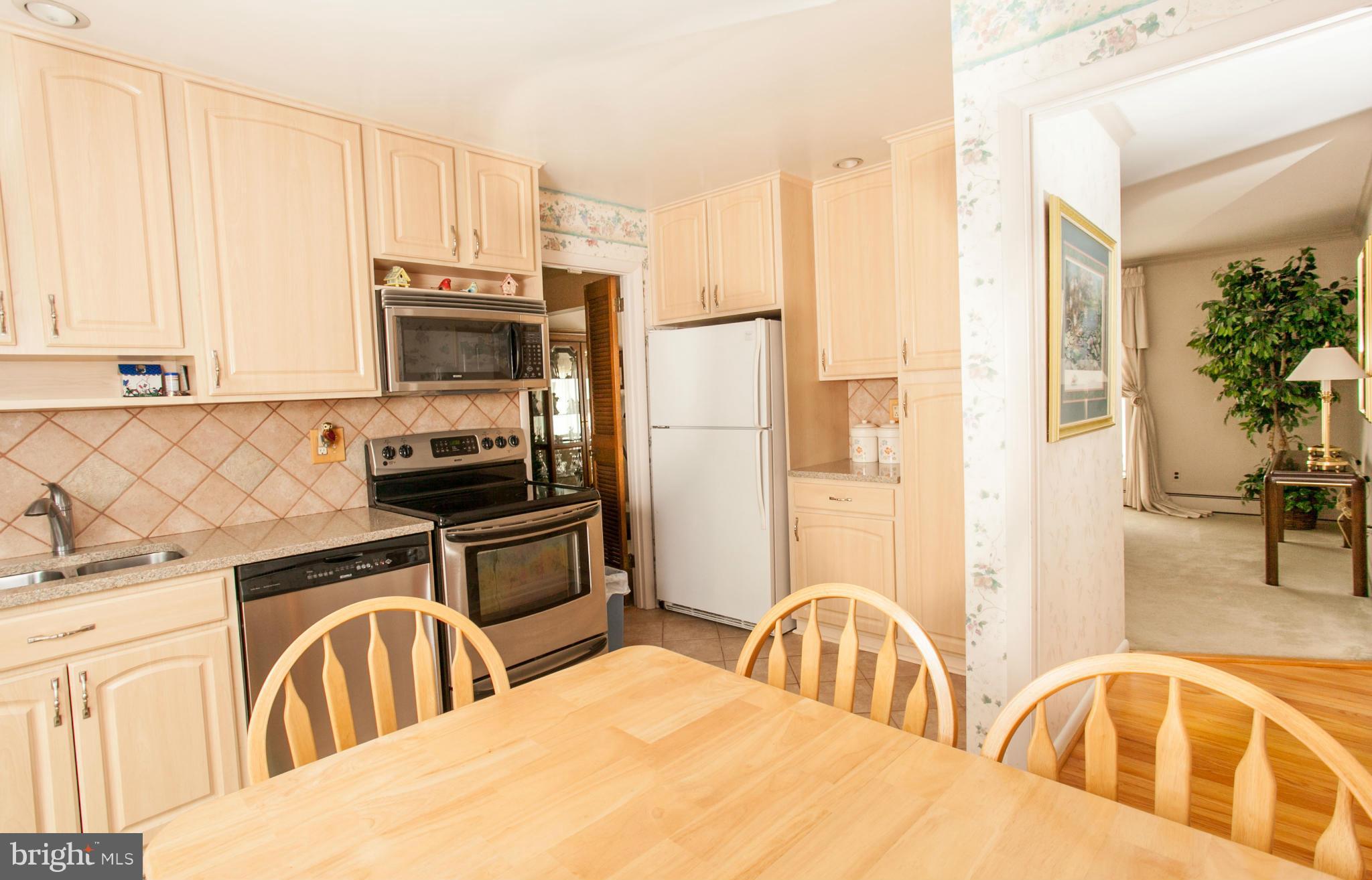 9914 Marilynn Road Perry Hall, MD 21128 - Photo 6 of 25 a kitchen with stainless steel appliances a sink a stove a refrigerator cabinets and a window