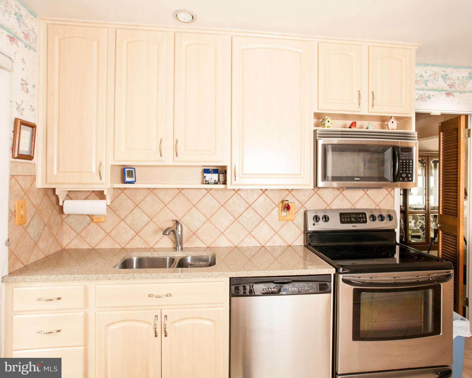 9914 Marilynn Road Perry Hall, MD 21128 - Photo 7 of 25 a kitchen with stainless steel appliances a stove a microwave and a sink