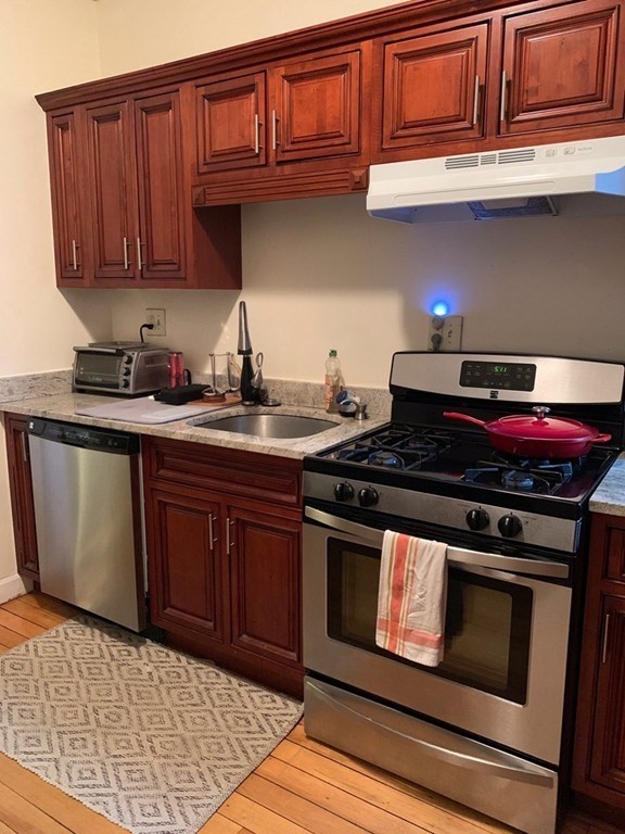 16 Royce Road, Unit 5 Boston, MA 02134 - Photo 3 of 10 a kitchen with stainless steel appliances granite countertop a stove and a sink