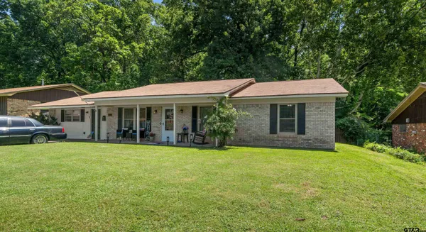 a kitchen with stainless steel appliances a stove top oven a refrigerator a dining table and chairs with wooden floor