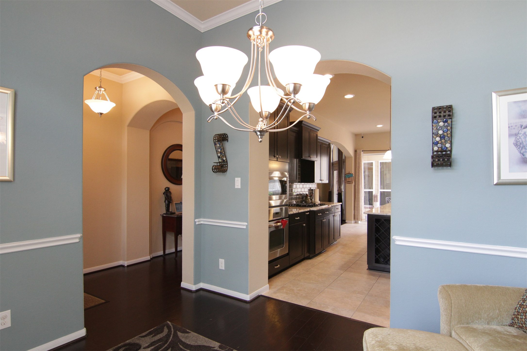 1423 Ralston Branch Way Sugar Land, TX 77479 - Photo 5 of 43 left arch from foyer, right arch to kitchen; dark wood floors throughout entry, dining, family room, and hall to bedrooms