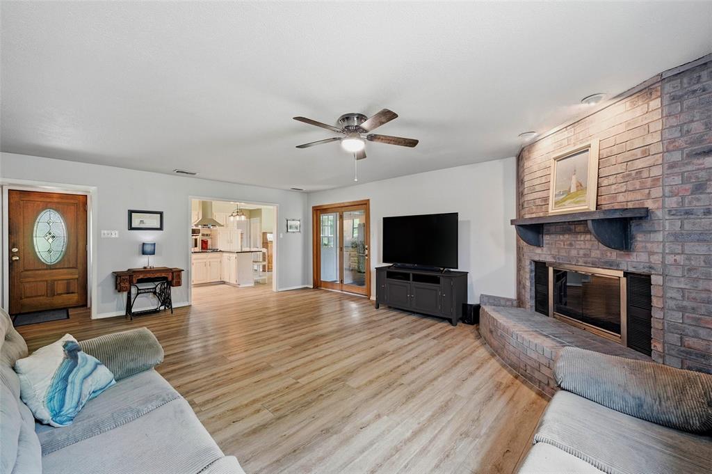 522 High Country Road Sherman, TX 75092 - Photo 7 of 38 a living room with furniture a fireplace a flat screen tv and kitchen view