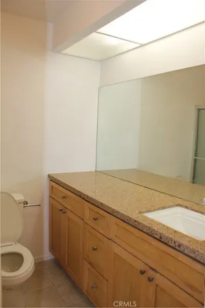 a bathroom with a granite countertop sink and toilet