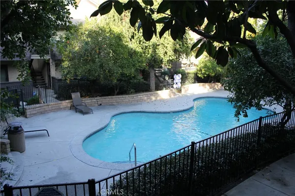 a view of a swimming pool with a patio and plants