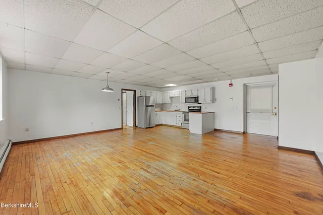 a view of empty room with wooden floor