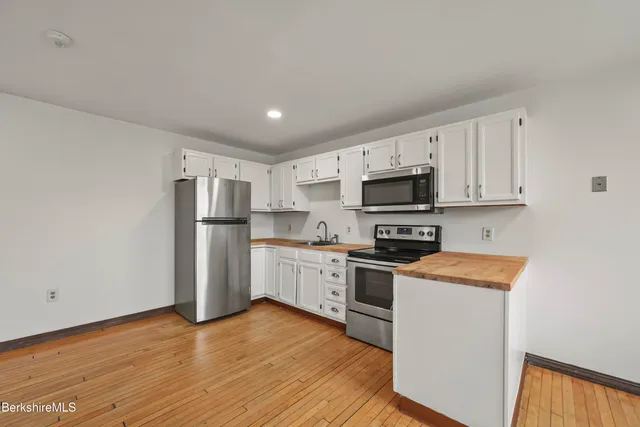a kitchen with stainless steel appliances granite countertop a refrigerator stove top oven and sink