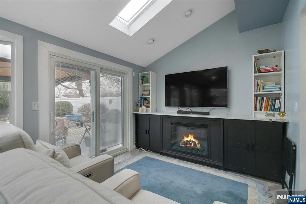 111 Crain Road Paramus, NJ 07652 - Photo 13 of 30 a living room with furniture a flat screen tv and a fireplace
