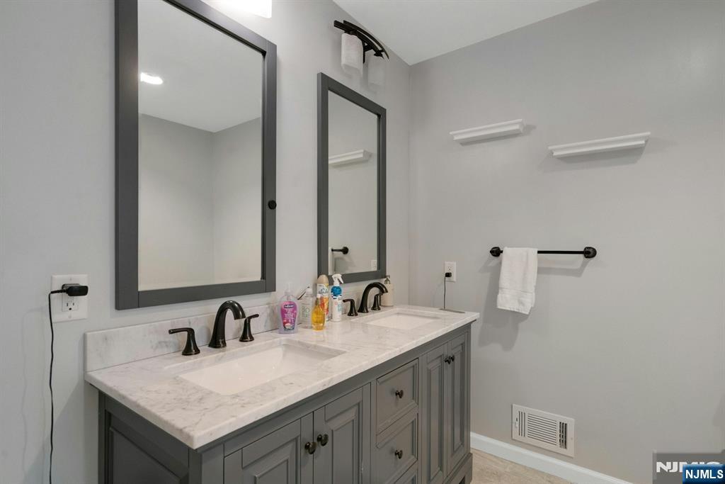 111 Crain Road Paramus, NJ 07652 - Photo 21 of 30 a bathroom with a granite countertop sink and a mirror