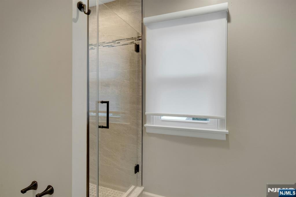 111 Crain Road Paramus, NJ 07652 - Photo 22 of 30 a bathroom with a glass shower door