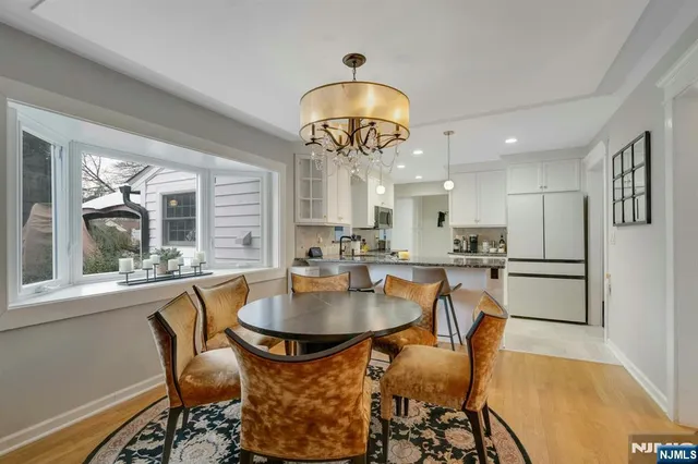 a dining room with furniture a chandelier and wooden floor
