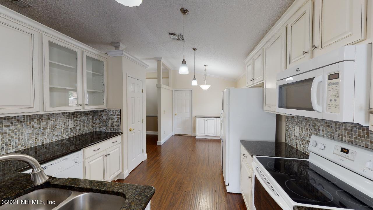 3130 Mountain Ash Road South Jacksonville, FL 32223 - Photo 13 of 60 a kitchen with white cabinets and stainless steel appliances
