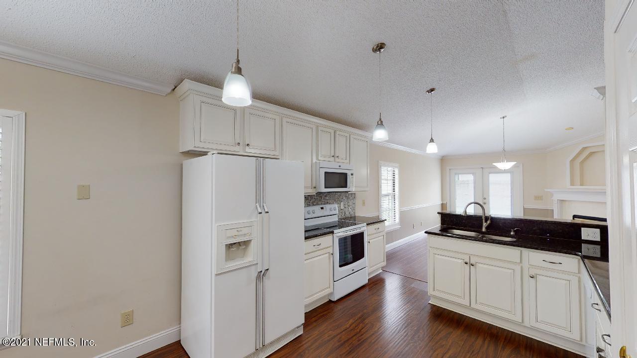 3130 Mountain Ash Road South Jacksonville, FL 32223 - Photo 17 of 60 a kitchen with stainless steel appliances granite countertop a refrigerator a stove a sink and white cabinets with wooden floor