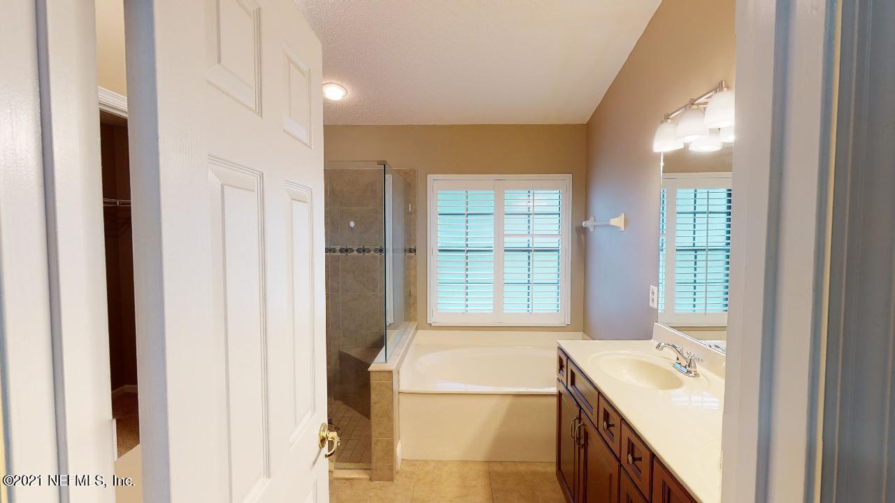 3130 Mountain Ash Road South Jacksonville, FL 32223 - Photo 25 of 60 a bathroom with a tub sink and windows