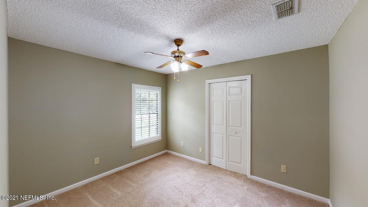 3130 Mountain Ash Road South Jacksonville, FL 32223 - Photo 32 of 60 an empty room with windows and ceiling fan