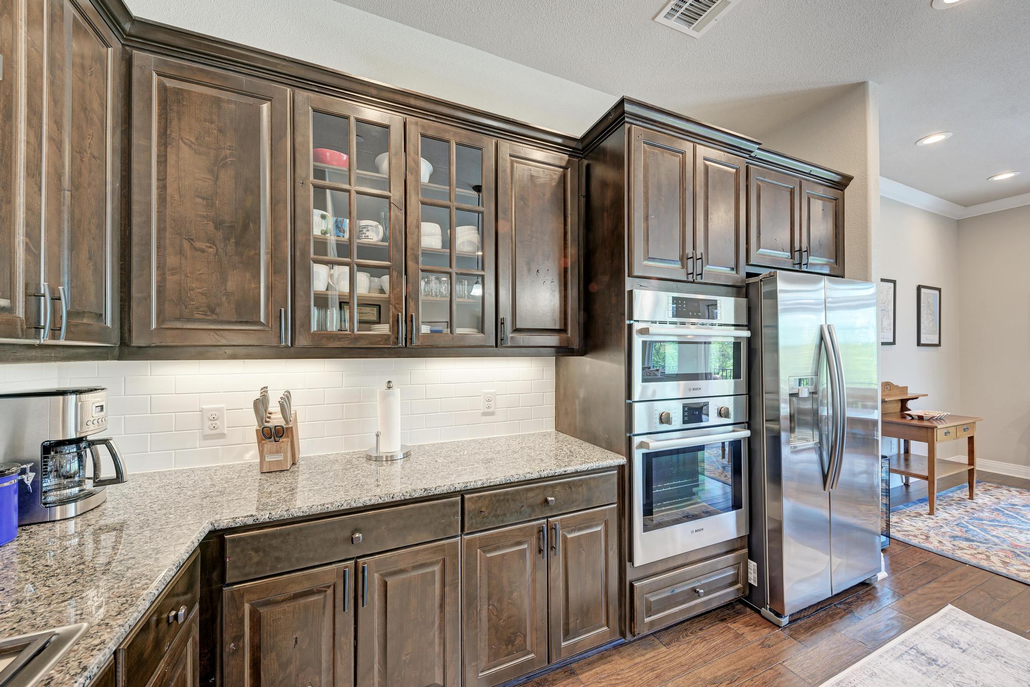 2601 North Quinlan Park Road, Unit 506 Austin, TX 78732 - Photo 18 of 39 A well-appointed kitchen boasts sleek dark wood cabinetry and modern stainless steel appliances.