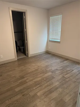 an empty room with wooden floor and closet