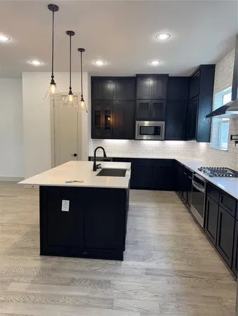 a kitchen with stainless steel appliances granite countertop a sink counter space and cabinets