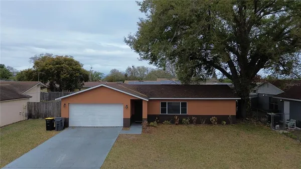 a front view of house with yard and trees in the background