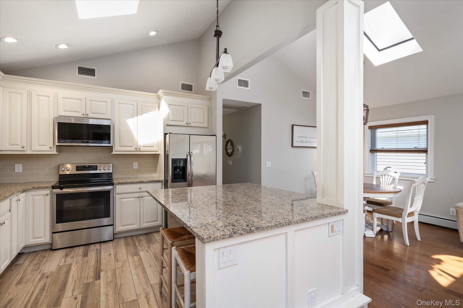 126 Walnut Road Kings Park, NY 11754 - Photo 10 of 33 a kitchen with stainless steel appliances granite countertop a sink dishwasher stove and microwave with wooden floor