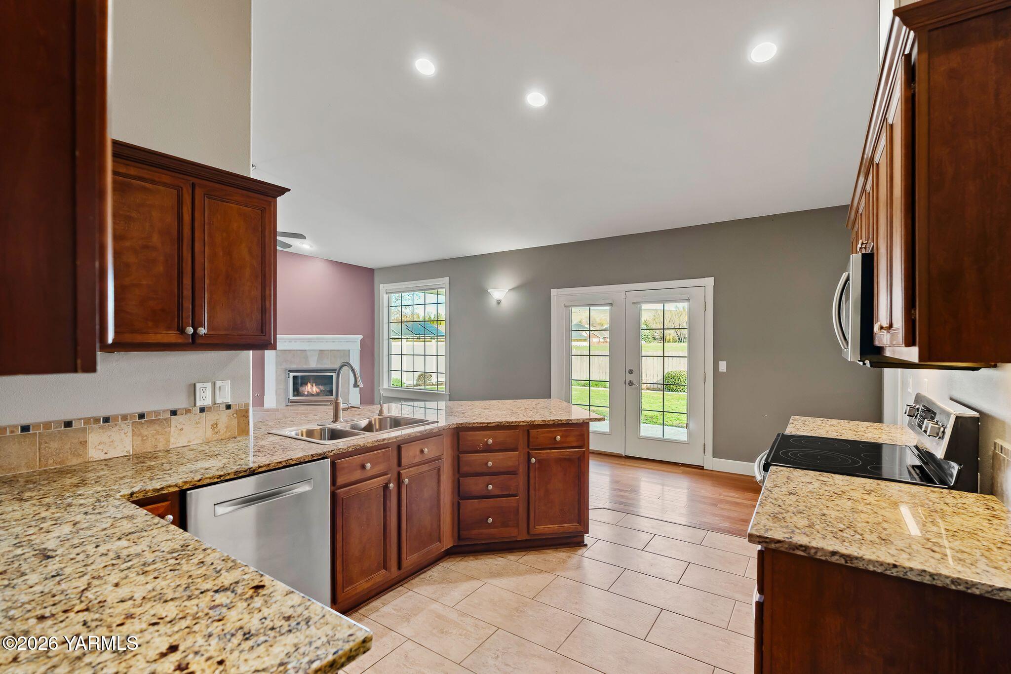 8507 Midvale Road Yakima, WA 98908 - Photo 10 of 24 a large kitchen with kitchen island granite countertop a sink dishwasher stove and cabinets