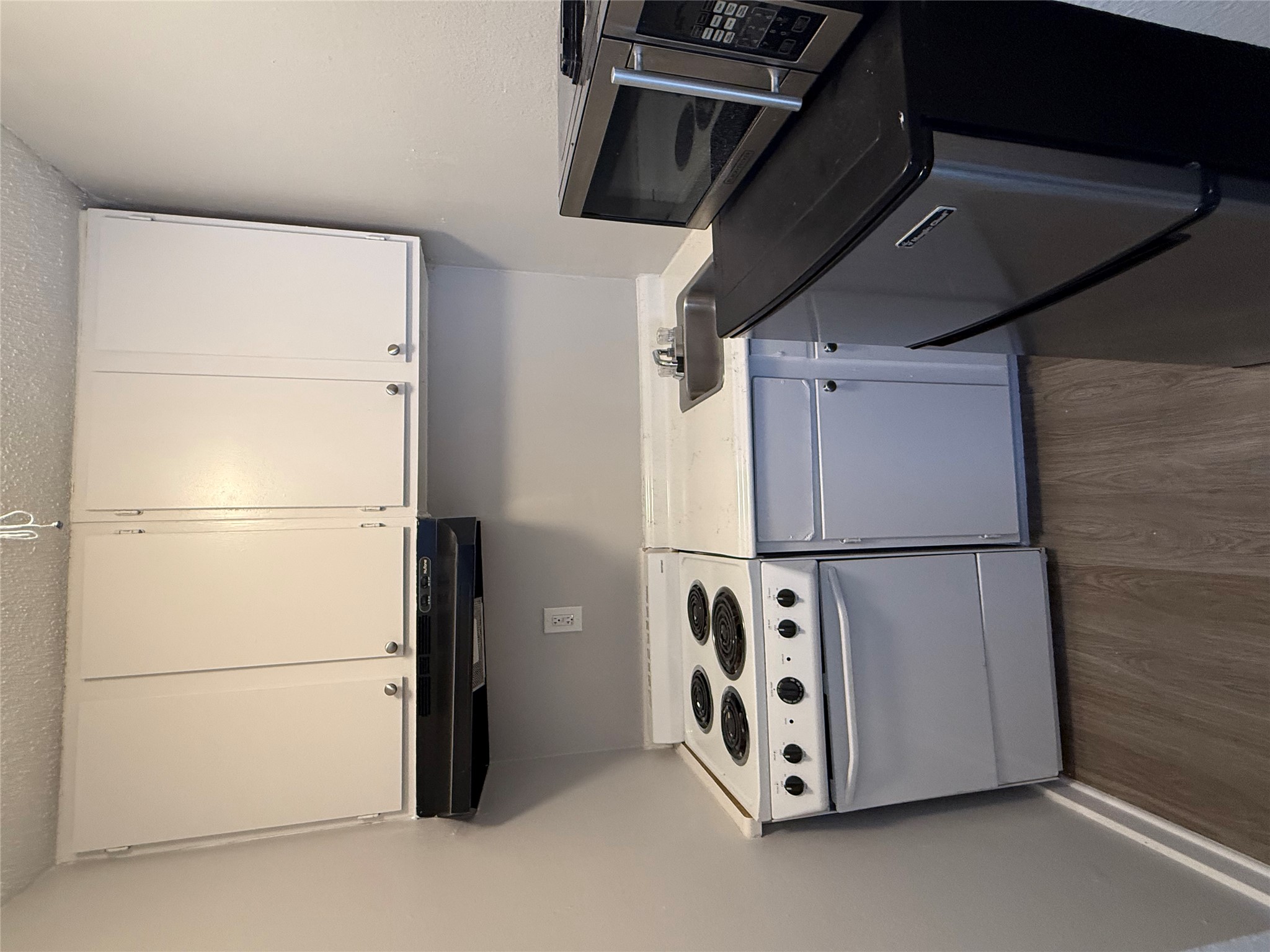 311 East 31st Street, Unit 203B Austin, TX 78705 - Photo 3 of 8 a kitchen with granite countertop a stove and a white cabinets
