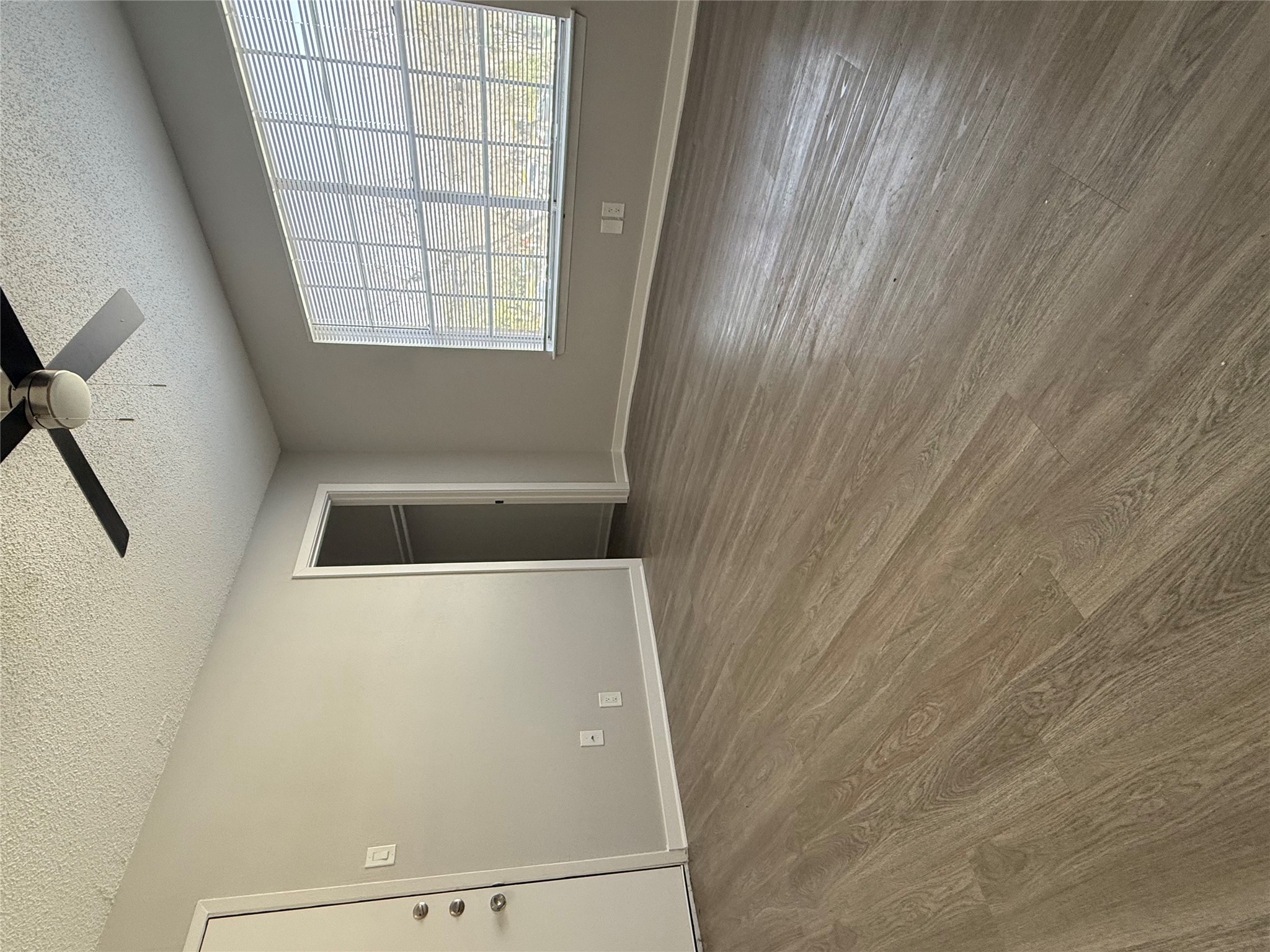 311 East 31st Street, Unit 203B Austin, TX 78705 - Photo 4 of 8 an empty room with wooden floor fan and windows