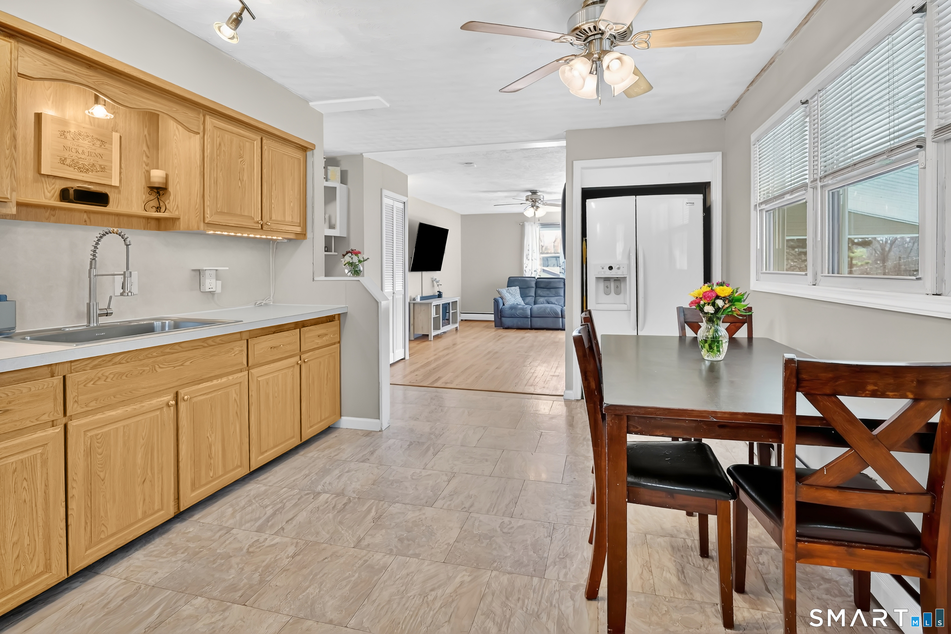 15 Meade Lane Enfield, CT 06082 - Photo 4 of 31 a kitchen with stainless steel appliances granite countertop a sink dishwasher a dining table and chairs with wooden floor