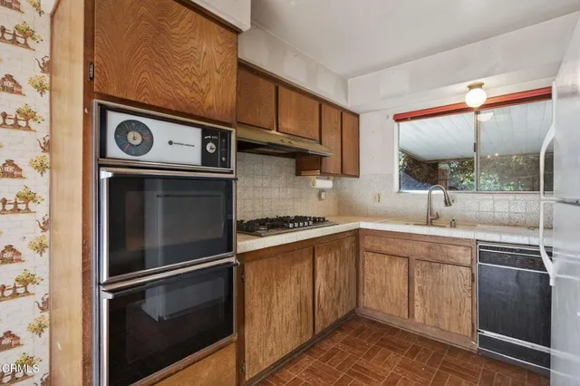 a kitchen with a sink and a stove top oven
