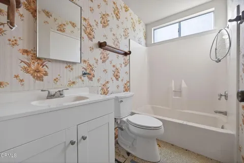 a bathroom with a sink toilet vanity and shower